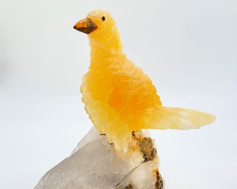 Gelber Vogel aus Kristall auf einem grauen Felsen, detailreich und glänzend.